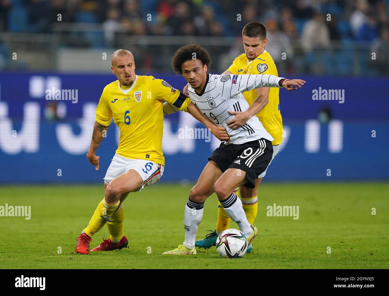 Hamburg, Germany. 08th Oct, 2021. Football: World Cup Qualification Europe, Germany - Romania, Group Stage, Group J, Matchday 7 at Volksparkstadion. Germany's Leroy Sane (M) fights for the ball with Romania's Vlad Chiriches (l) and Romania's Razvan Marin. Credit: Marcus Brandt/dpa/Alamy Live News Stock Photo