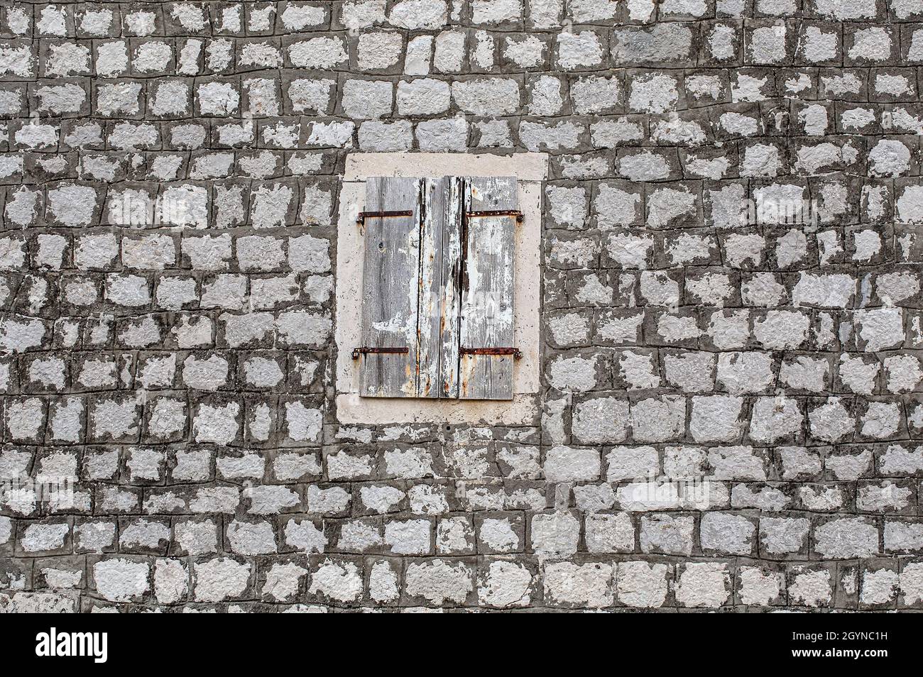 old house stone wall, with cracked window shutters in light wood Stock ...