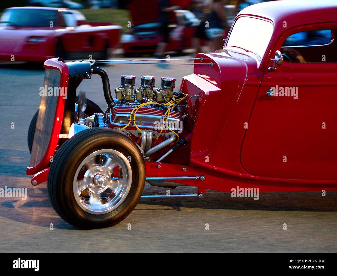 KANSAS CITY, UNITED STATES - Jul 14, 2013: A selective focus shot of a red classic V8 engine automobile driving Stock Photo