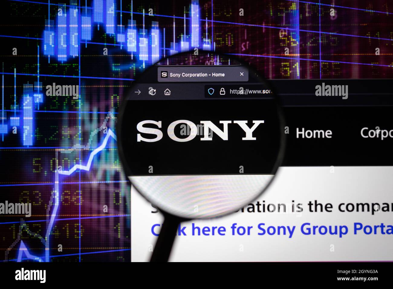 Sony company logo on a website with blurry stock market developments in the background, seen on a computer screen through a magnifying glass Stock Photo