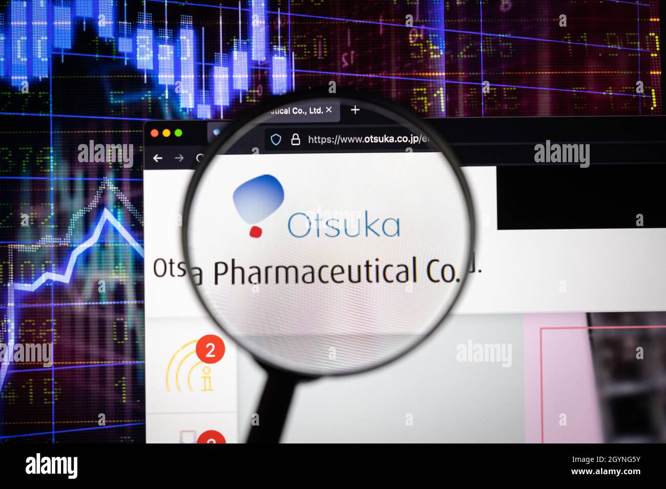 Otsuka company logo on a website with blurry stock market developments in the background, seen on a computer screen through a magnifying glass Stock Photo