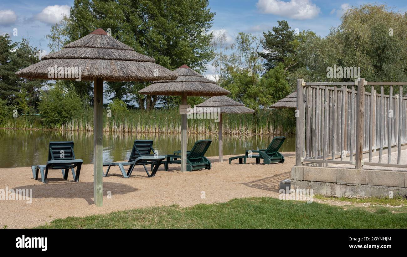 Lake with sand and sun loungers Stock Photo