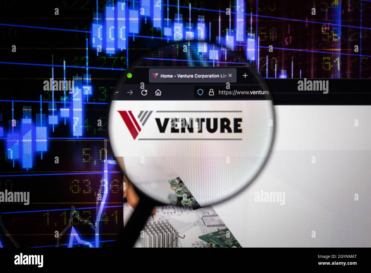 Venture company logo on a website with blurry stock market developments in the background, seen on a computer screen through a magnifying glass Stock Photo