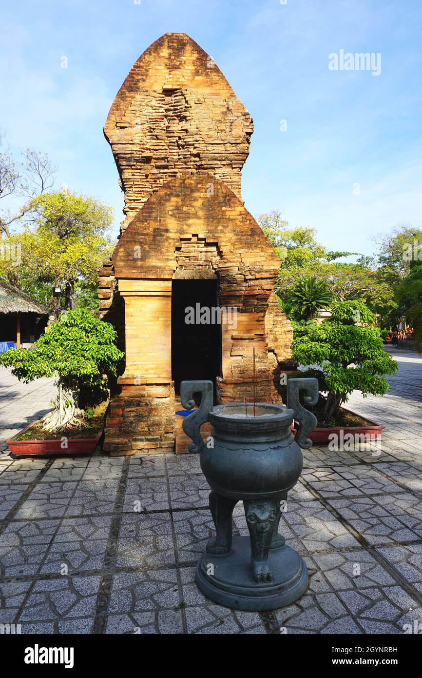 Partially restored ruins of one of the ancient Cham Towers with a bronze incense burner at Po Nagar Tower on Cù Lao Mountain in Nha Trang, Vietnam. Stock Photo