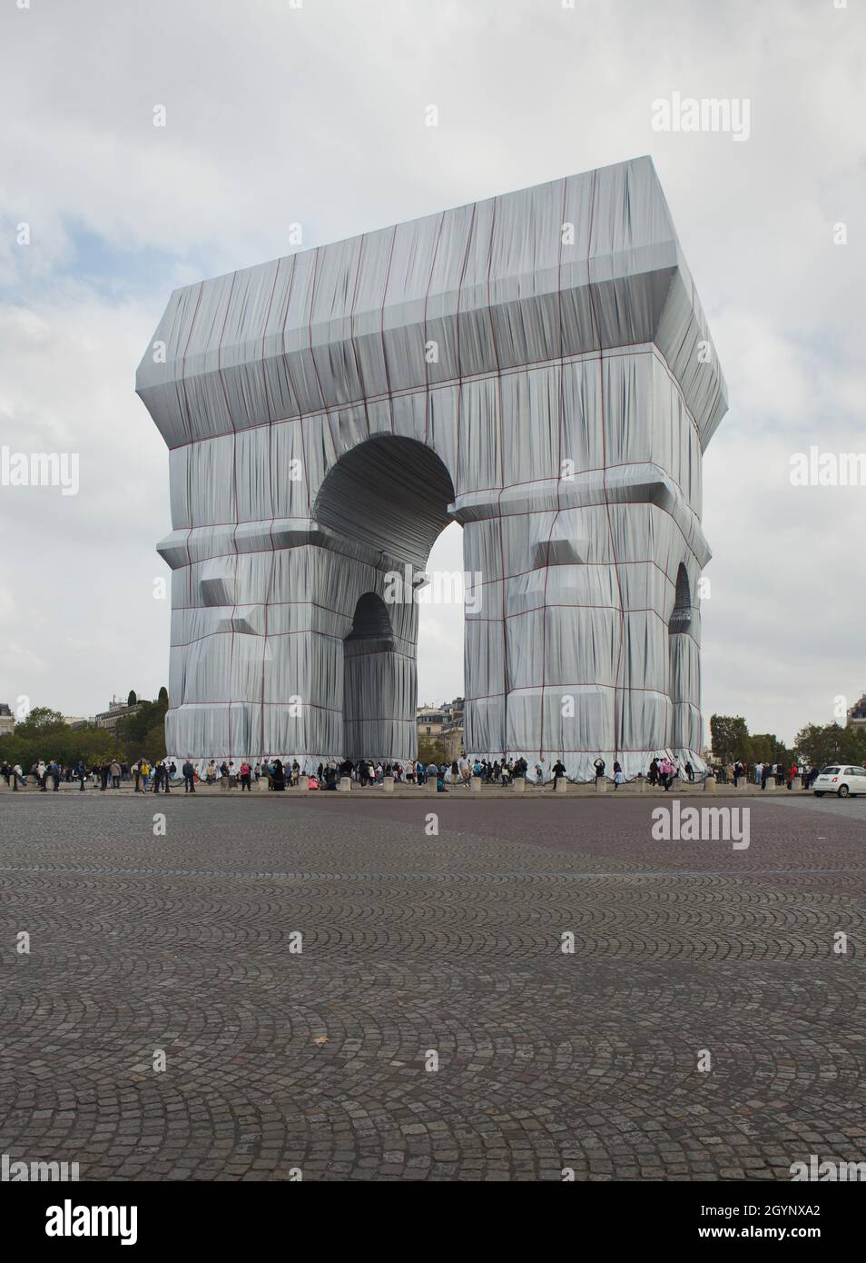 The Arc de Triomphe wrapped in silver-blue fabric fastened with red ropes in the Place Charles de Gaulle in Paris, France. The Arc de Triomphe was wrapped for two weeks being converted to an artwork as it was designed by Christo and Jeanne-Claude in September 2021. Stock Photo