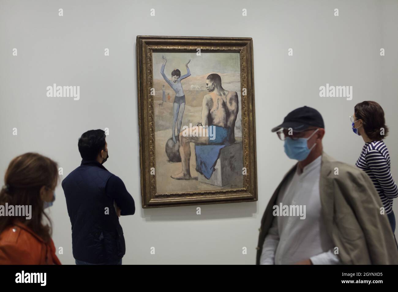 Visitors wearing face masks in front of the painting 'Young Acrobat on a  Ball' by Pablo Picasso (1905) displayed at the exhibition 'Icons of Modern  Art from the Morozov Collection' in the
