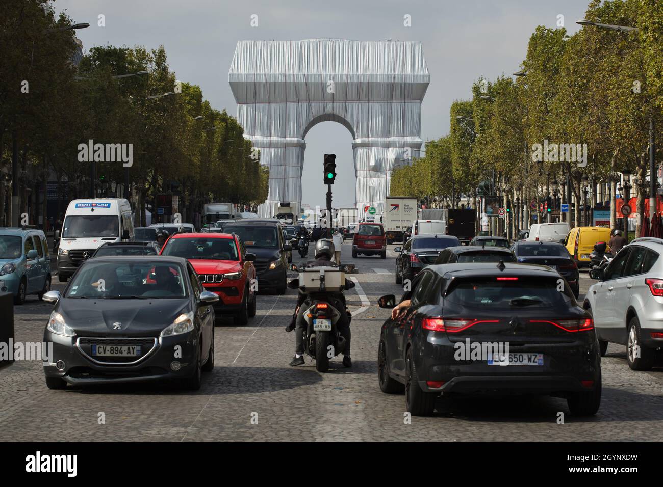 The Arc de Triomphe wrapped in silver-blue fabric fastened with red ropes pictured from the Avenue des Champs-Élysées in Paris, France. The Arc de Triomphe was wrapped for two weeks being converted to an artwork as it was designed by Christo and Jeanne-Claude in September 2021. Stock Photo