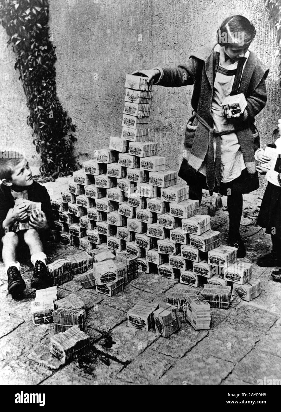Children using blocks of worthless money like building blocks to build a castle. Stock Photo