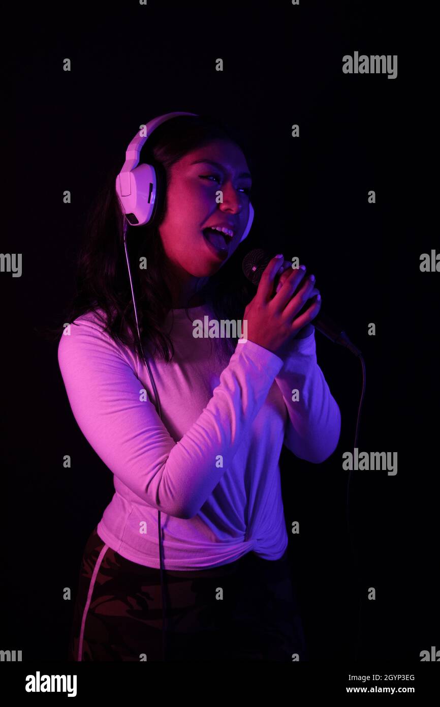 Girl singing with microphone in hand Stock Photo