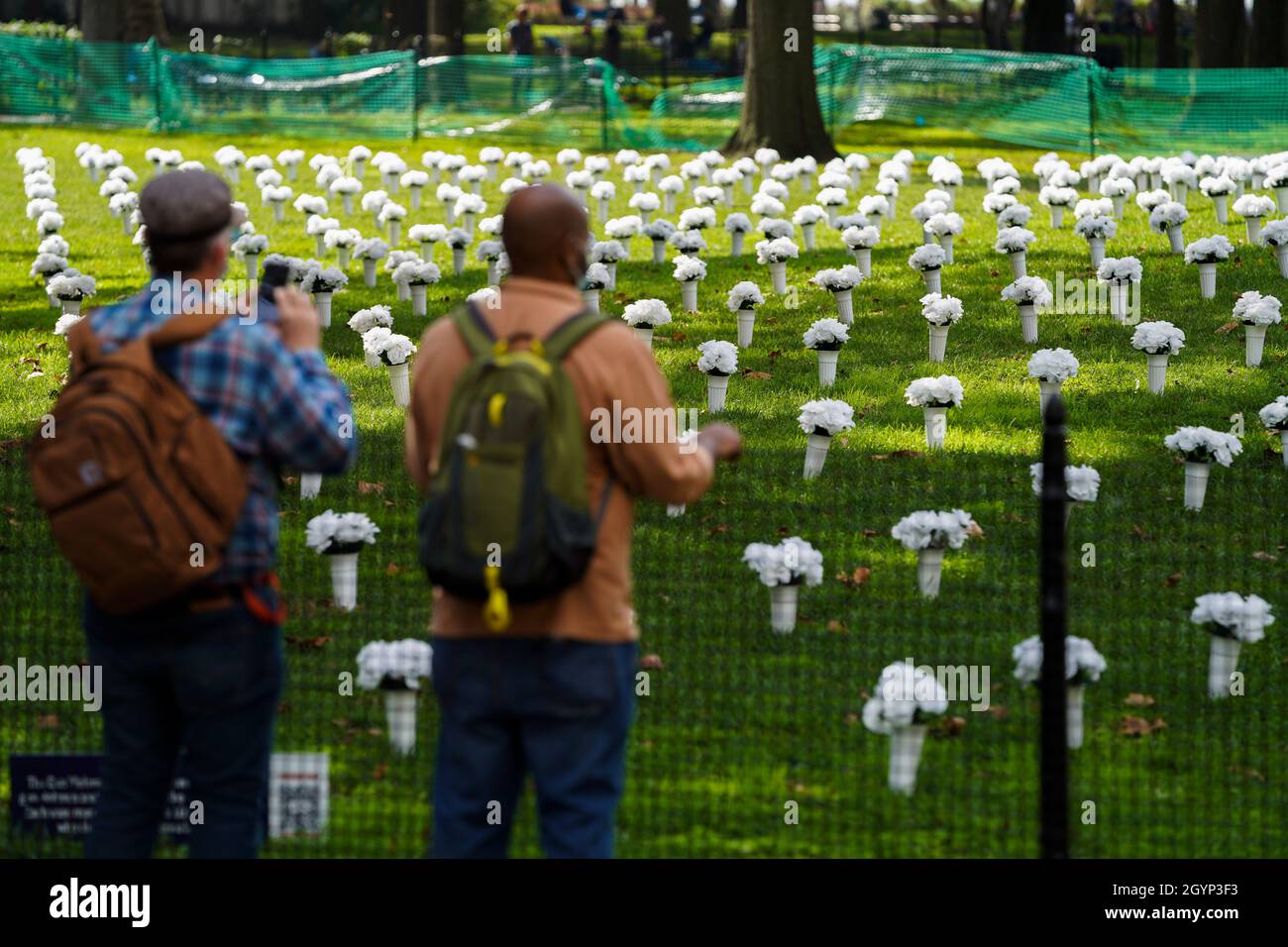 New York, USA. 8th Oct, 2021. People look at the vases of flowers
