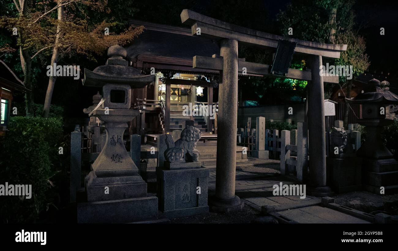 Stone torii gate and little shinto altar at Yasaka Jinja shrine in night. Gion Temple is one of the most famous shrines in Kyoto. Japan Tochigi prefec Stock Photo