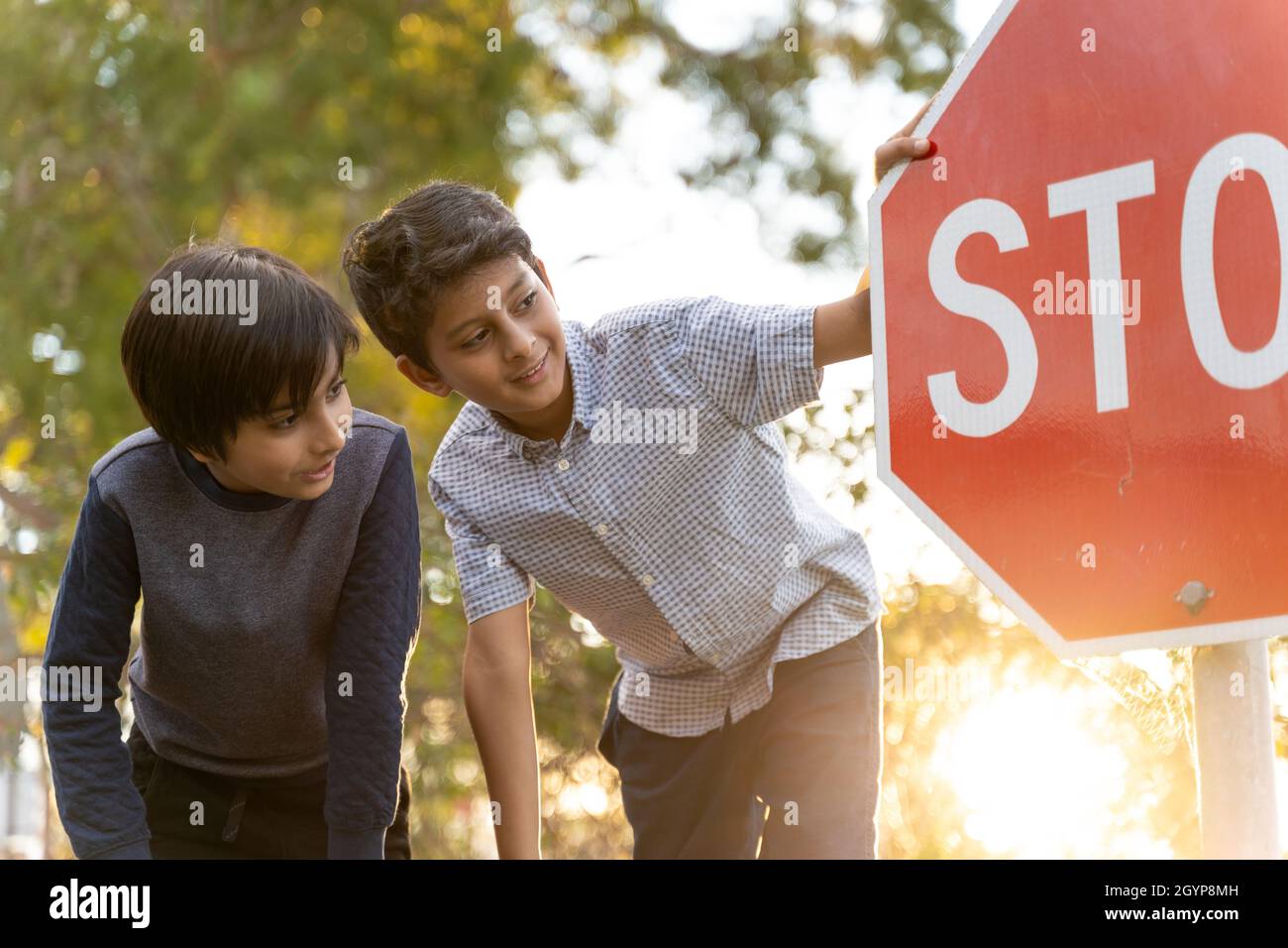 Friendship concept with diverse kids. Two kids laughing next to stop street sign. Overcoming barriers concept, childhood memories. Stock Photo
