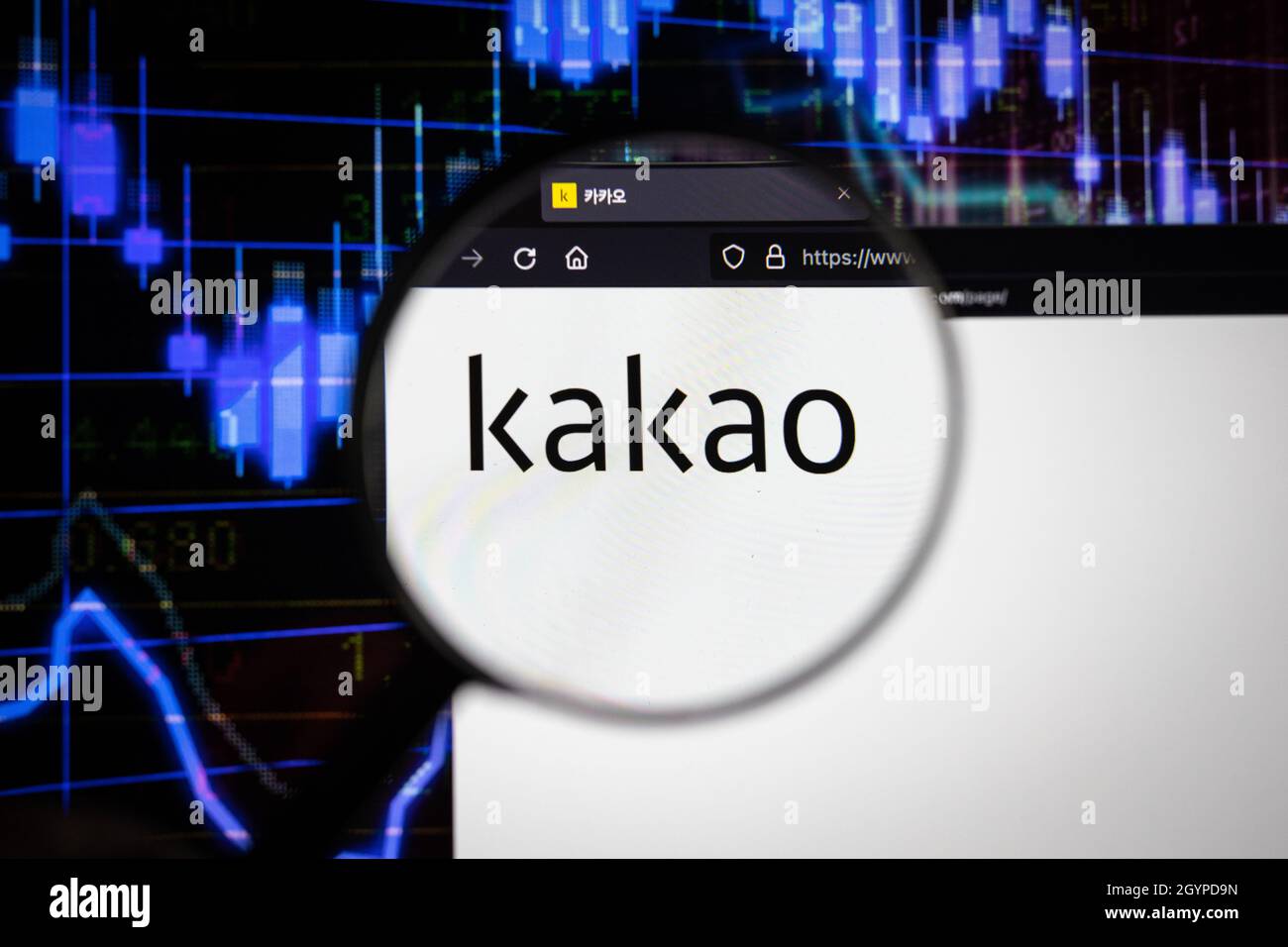 Kakao company logo on a website with blurry stock market developments in the background, seen on a computer screen through a magnifying glass Stock Photo