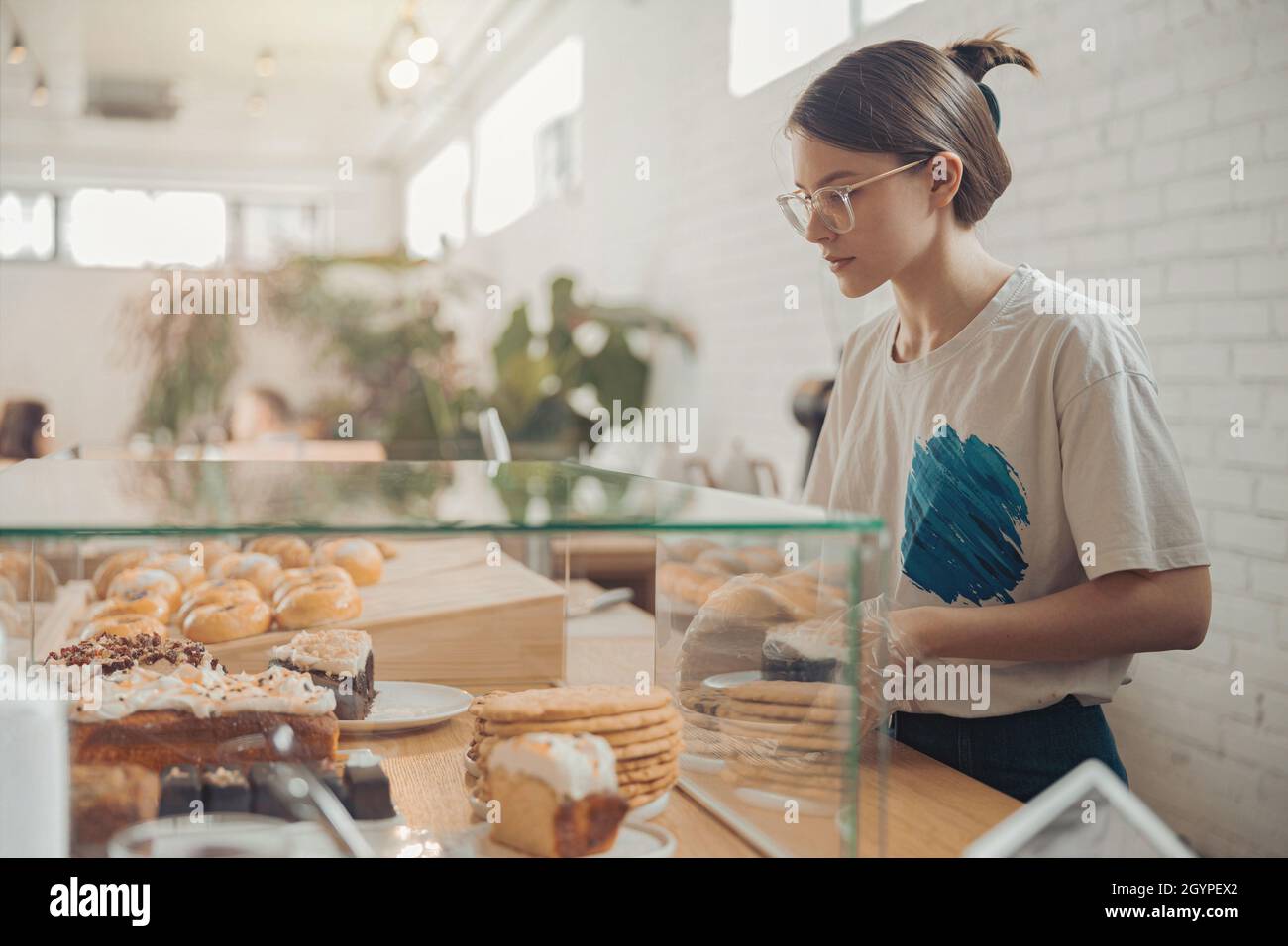 Charming young woman working in bakery shop Stock Photo