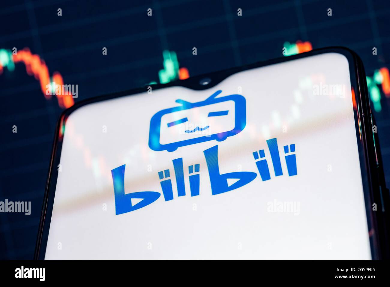 A smartphone with the Bilibili logo on the background of the stock chart. Stock Photo