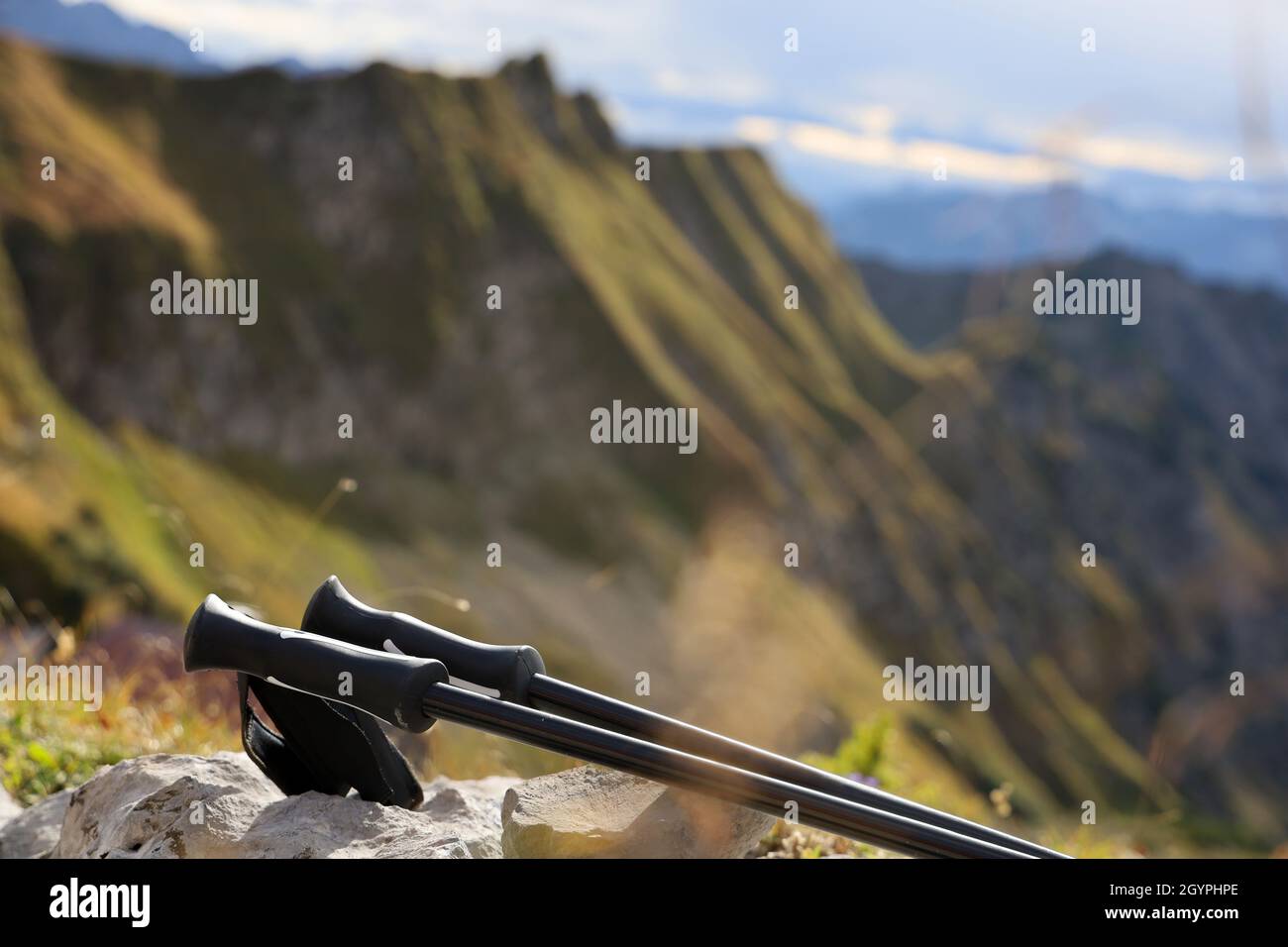 close up of trekking sticks for hiking in the mountains lies in front of a mountain landscape with copy space Stock Photo
