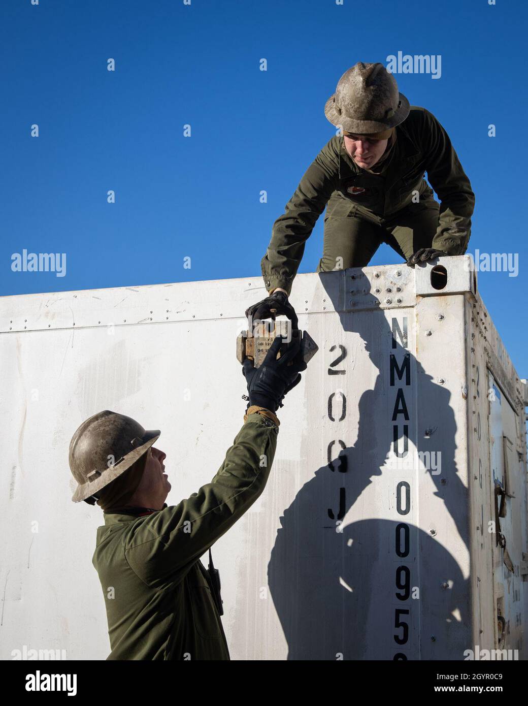 Marine Cpl. Matthew Swanson, top, hands a container twist lock to Staff Sgt. Steven Beall in support of exercise Carolina Patriot 2020 in Philadelphia, Pennsylvania, Jan. 22, 2020. The exercise ensures 2nd Marine Aircraft Wing’s proficiency and readiness in aviation logistics support operations. Swanson is an aviation ordnance systems technician with Marine Aviation Logistics Squadron (MALS) 26. Beall is an aviation precision measurement equipment calibration/repair technician with MALS-14. (U.S. Marine Corps photo by Cpl. Cody Rowe) Stock Photo