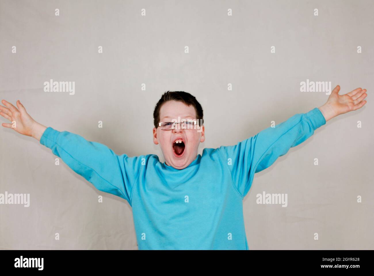 Smiling boy with arms outstretched demonstrating size Stock Photo