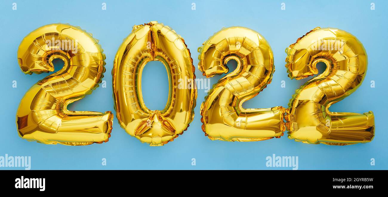2022 year gold balloons on blue wall background Flat lay. Happy New year 2022 eve celebration Stock Photo