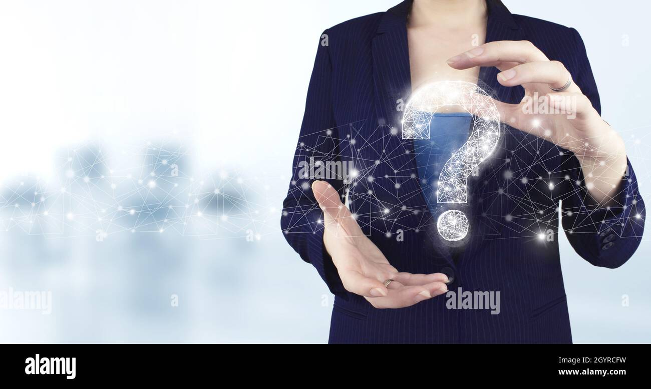 FAQ frequently asked questions concept. Two hand holding virtual holographic question mark icon with light blurred background. Business support concep Stock Photo