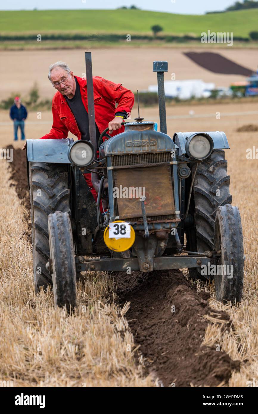 Mindrum Mill, Northumberland, England, UK, 9th October 2021. British Ploughing Championships: the 70th championships, cancelled due to Covid-19 last year, take place. A variety of tractor classes compete for prizes over the two day event. Pictured: a man driving a vintage Fordson tractor. Stock Photo
