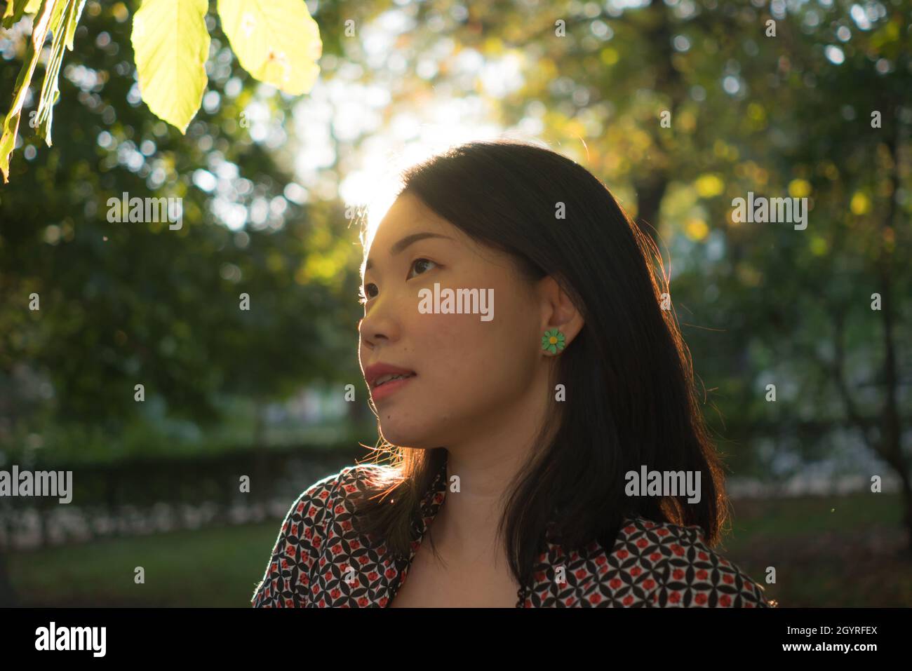 lifestyle portrait of young happy and beautiful Asian Chinese woman playful and relaxed on sunset at city park enjoying free celebrating nature and Au Stock Photo