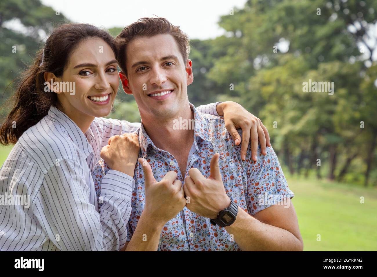 young couple man and woman falling in love and dating in the park. wife hugging and enjoying with smiling of her husband  in romantic travel holiday. Stock Photo