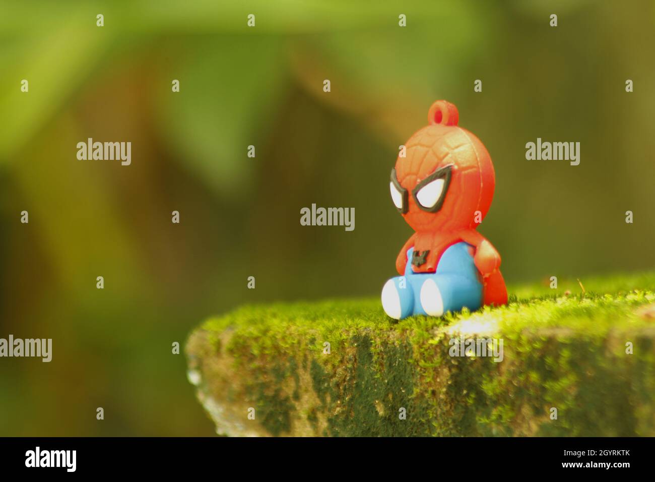 Closeup view of toy spiderman sitting on the moss Stock Photo