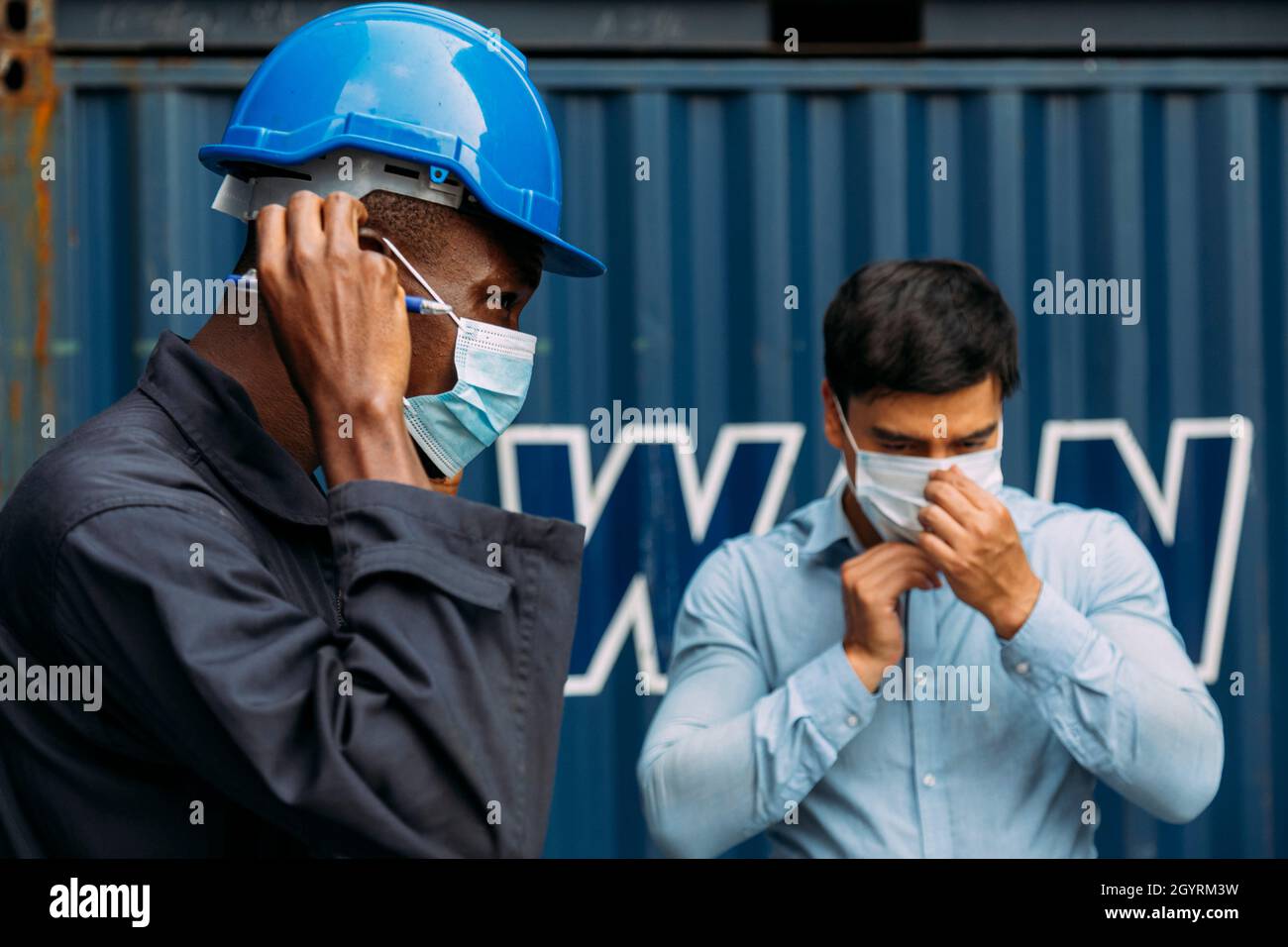 african worker and businessman wearing face mask to protect covid or coronavirus pandemic and pm2.5 bad air pollution from traffic and manufacturing i Stock Photo