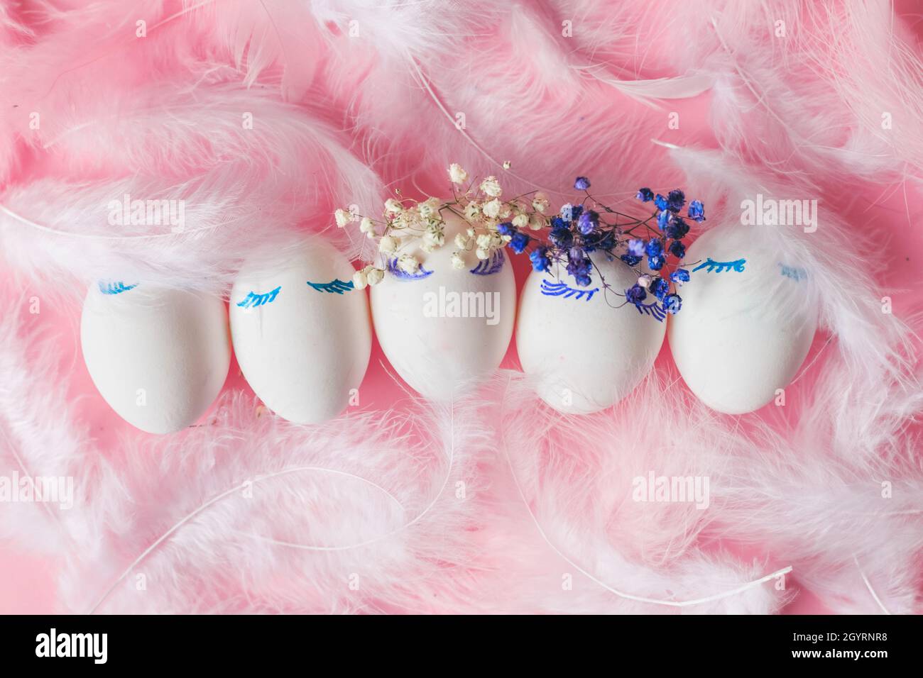 Happy Easter composition with easter eggs, flowers,feathers on pink background Stock Photo