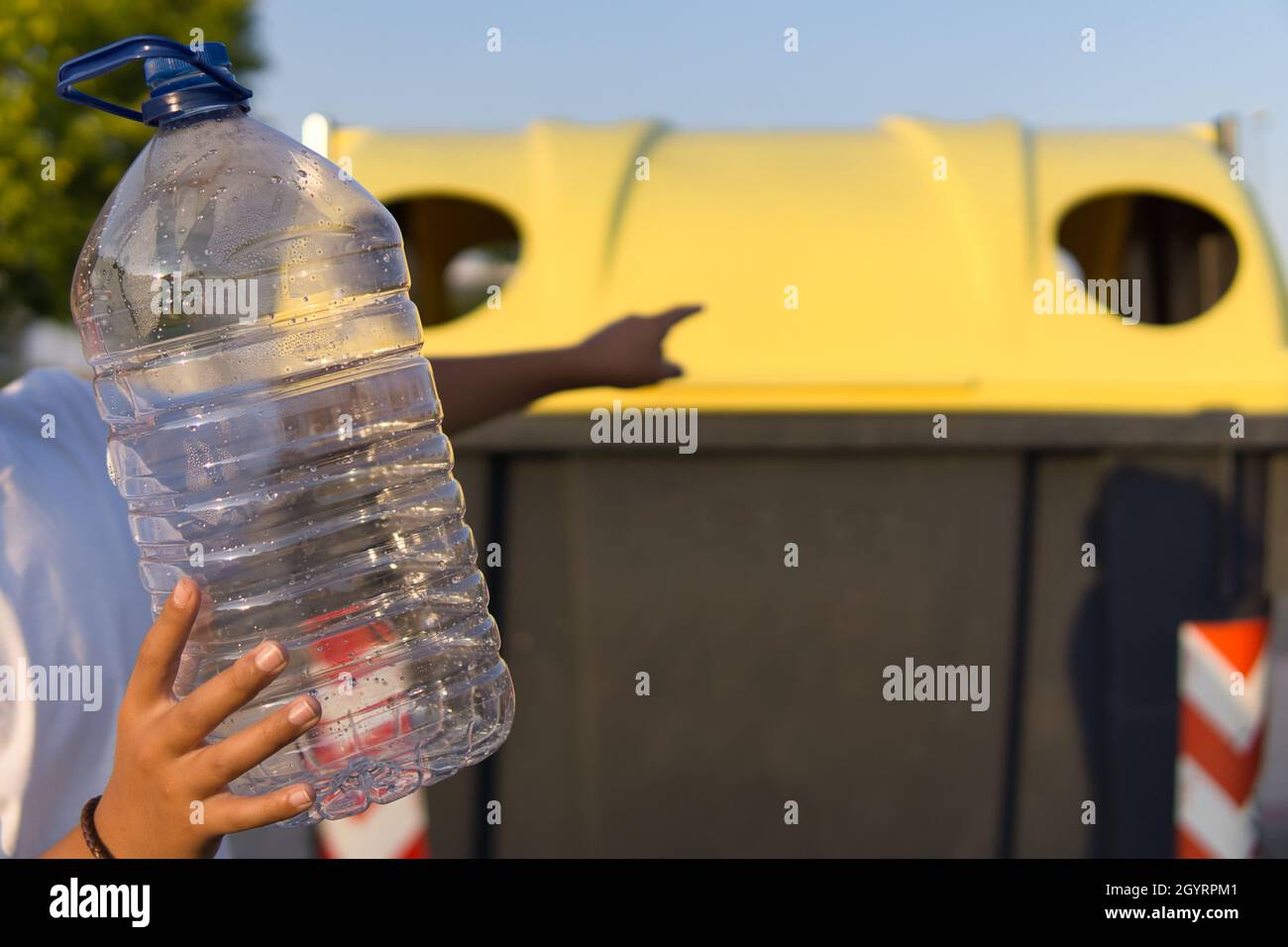 Young boy throwing a plastic bottle into the recycle bin Stock Photo