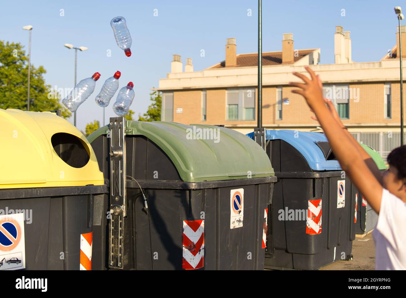 Young boy throwing a plastic bottle into the recycle bin Stock Photo