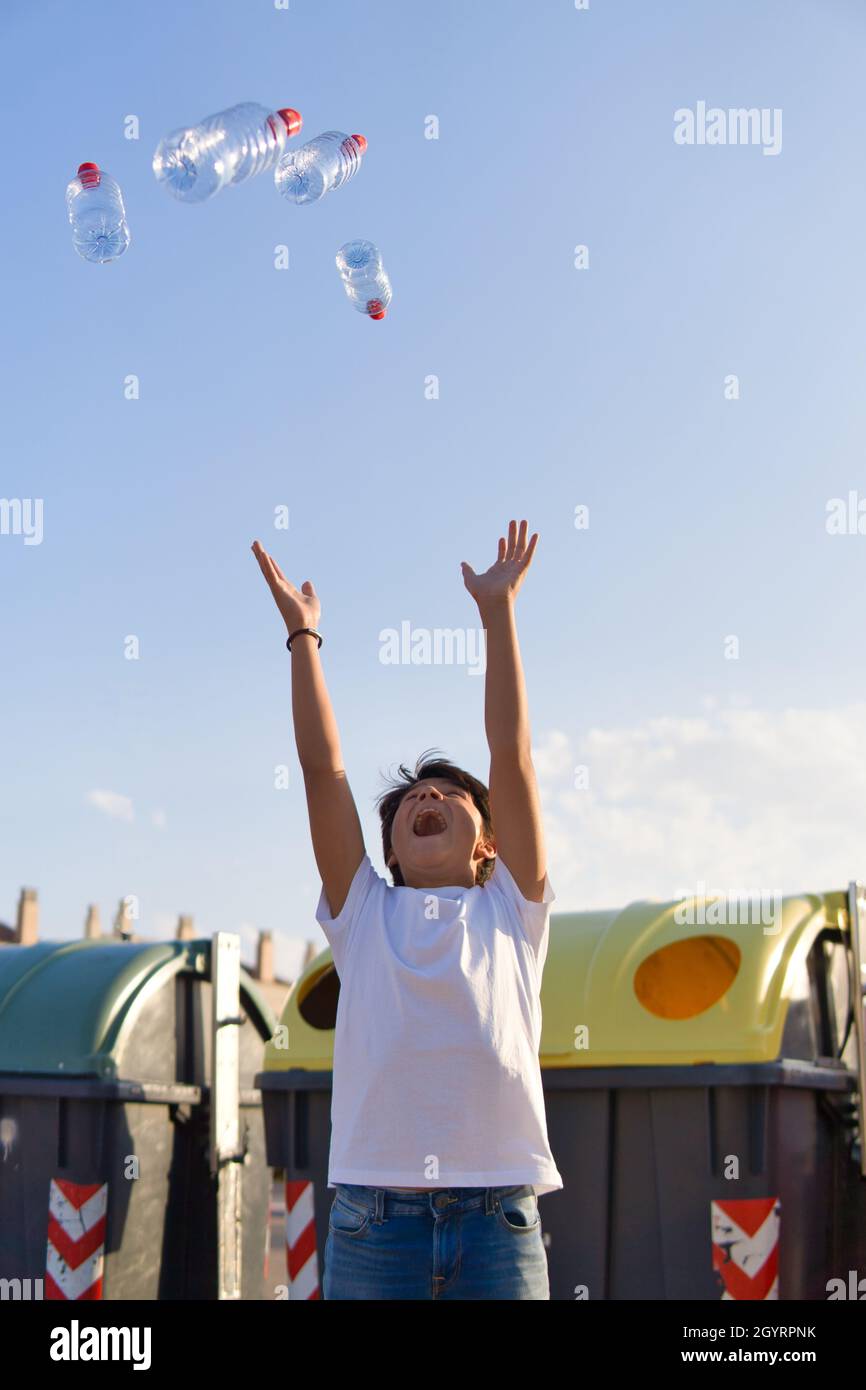 Young boy throwing plastic bottles into the air Stock Photo Alamy