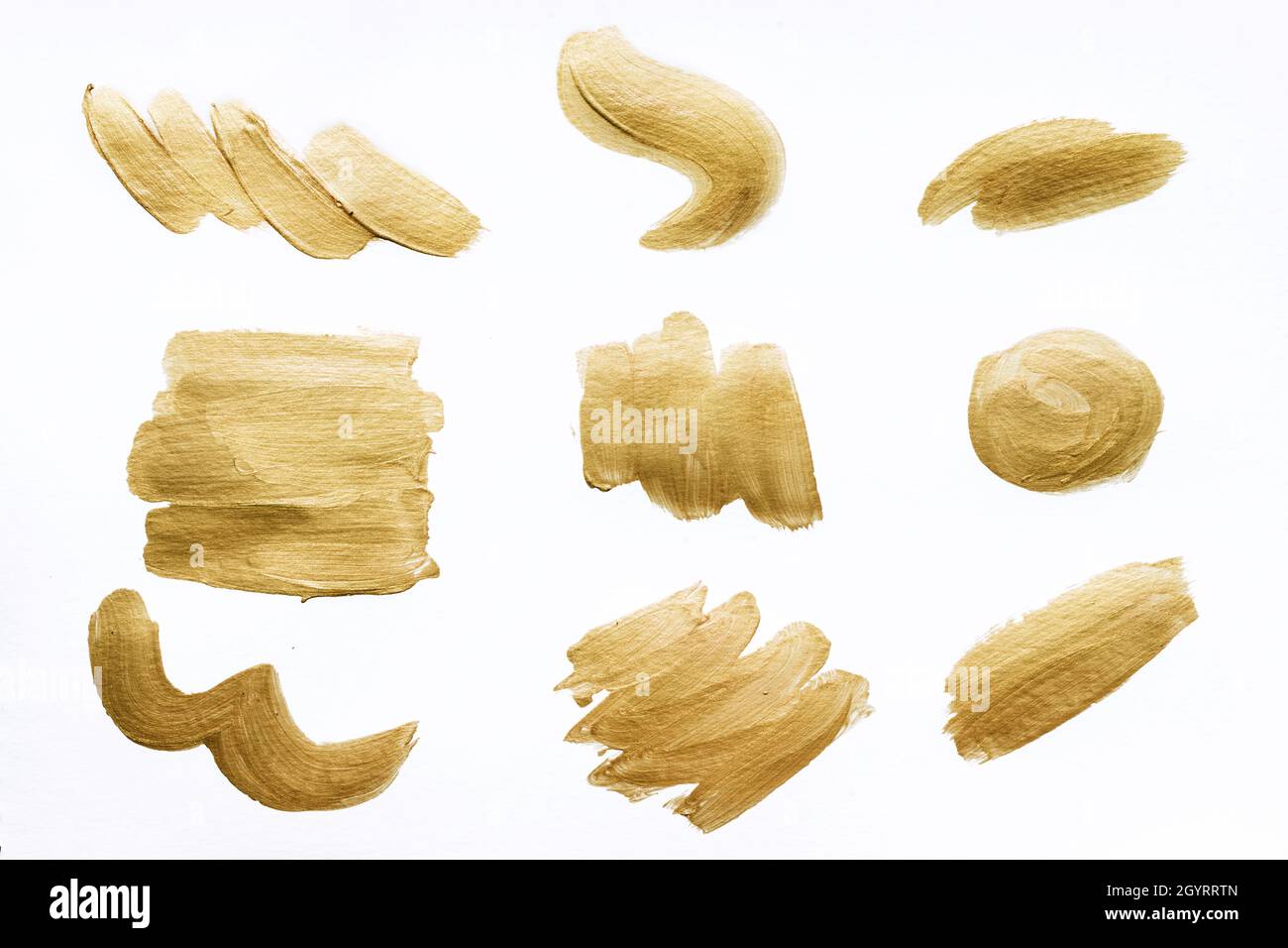 Collection of gold brush strokes isolated on white background. Stock Photo