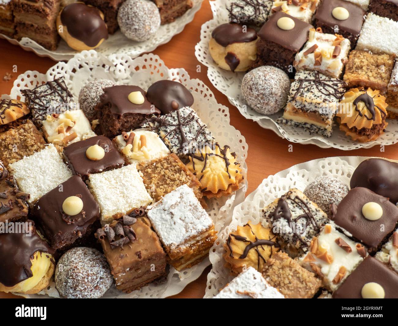 Closeup shot of tasty pastry assortment on the white plate on a wooden ...