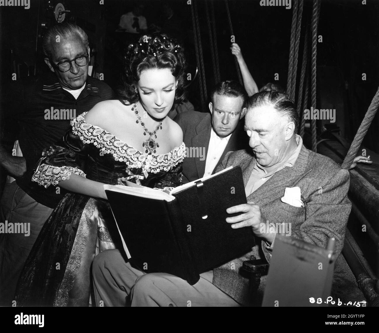 1st Assistant Director JAMES CASEY LINDA DARNELL Dialogue Director HAL LONG and Director RAOUL WALSH discuss the script on set candid during filming of BLACKBEARD THE PIRATE 1952 director RAOUL WALSH story DeVallon Scott screenplay Alan Le May costume design Michael Woulfe music Victor Young producer Edmund Grainger RKO Radio Pictures Stock Photo