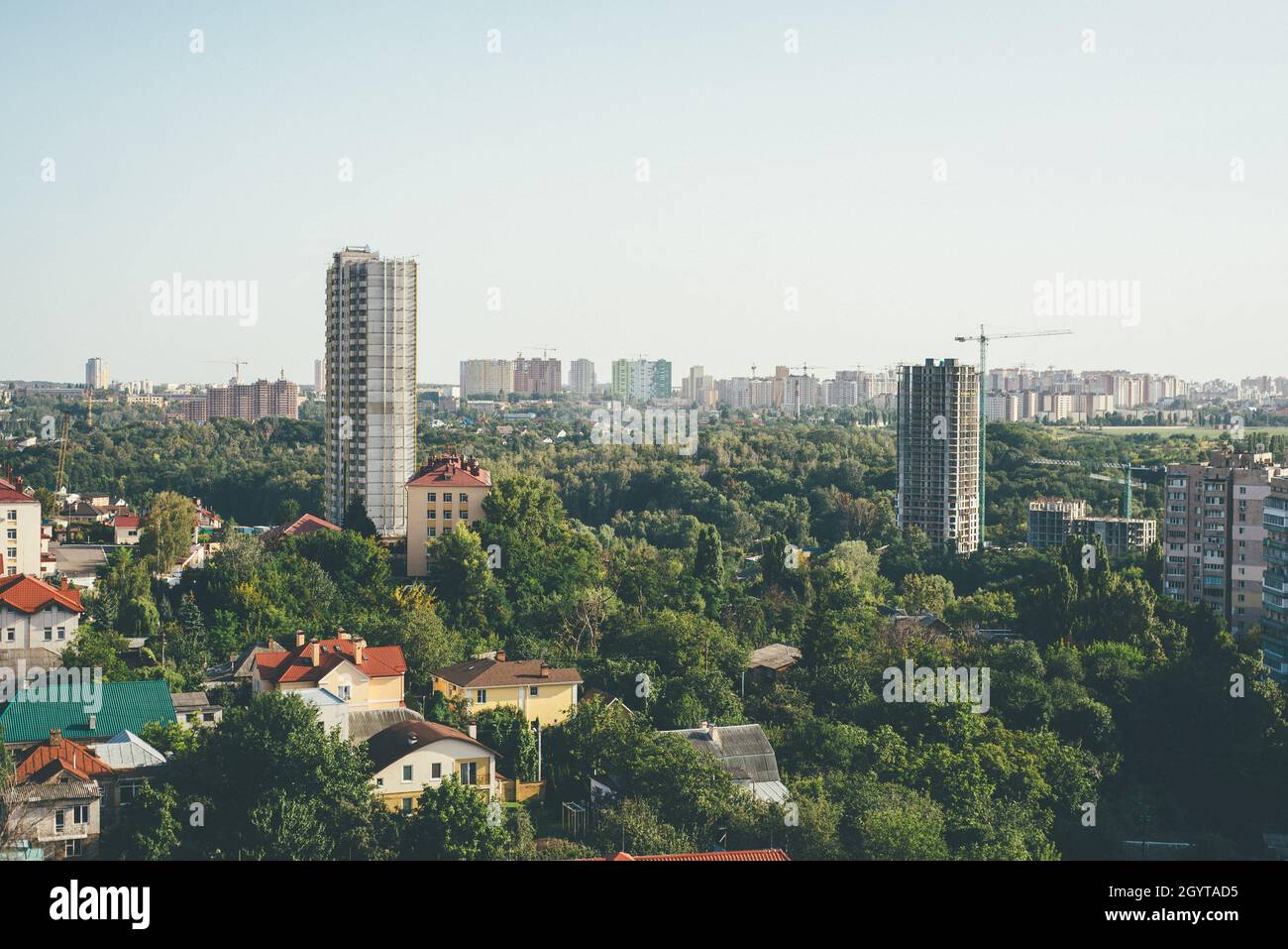 Kyiv city urbanistic lanscape of two buildins under constructions between green tree crones Stock Photo