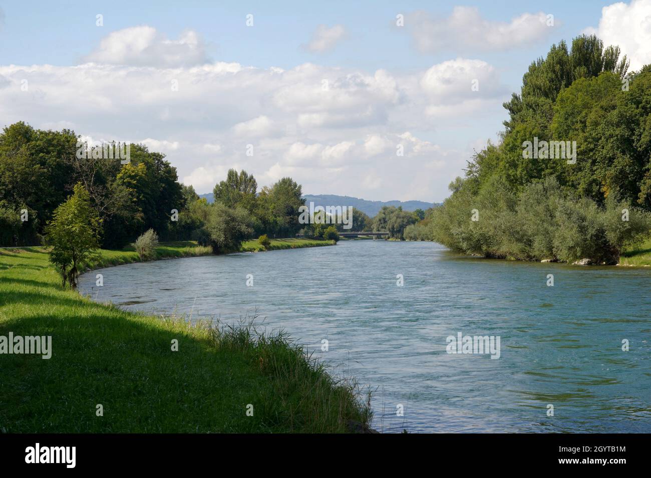 River Limmat in canton Zurich, Switzerland in summertime. There are trees on both banks and a walking path on the left side. Stock Photo