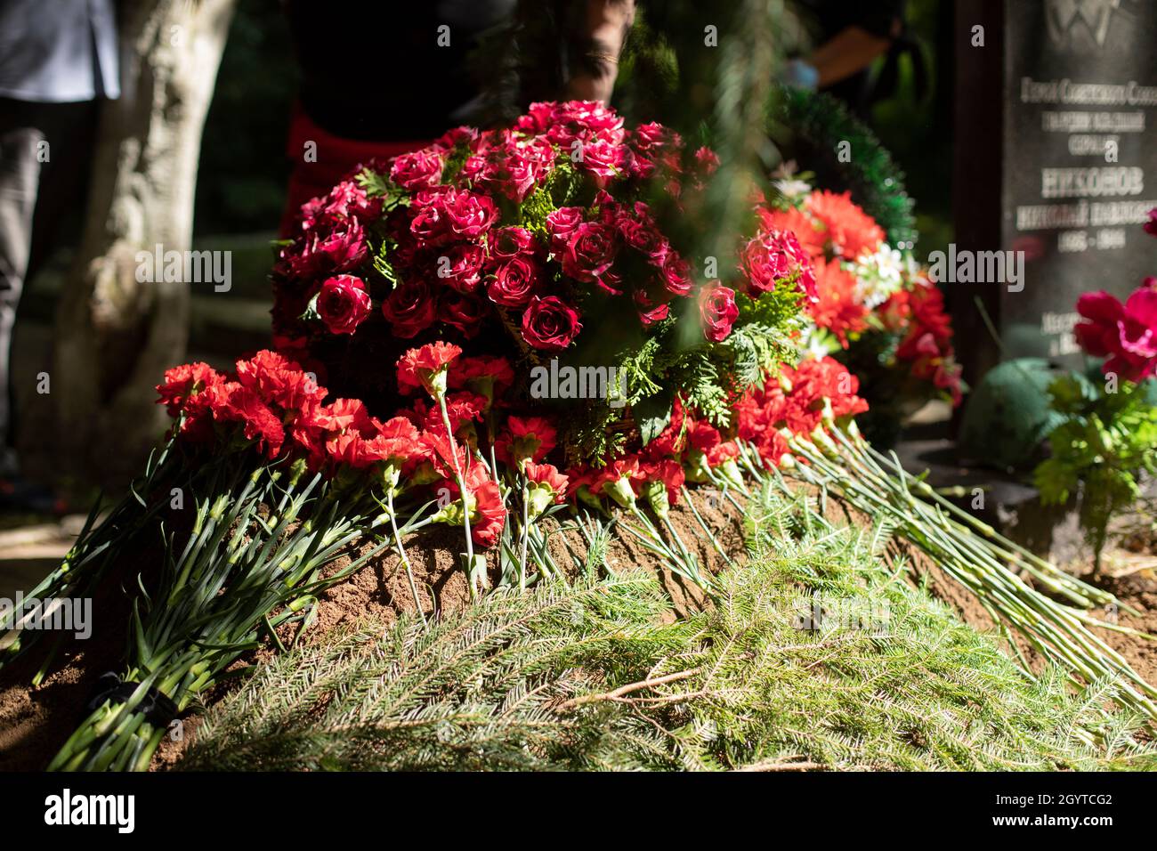Flowers on the grave. Funeral ceremony. Flowers lie on the ground