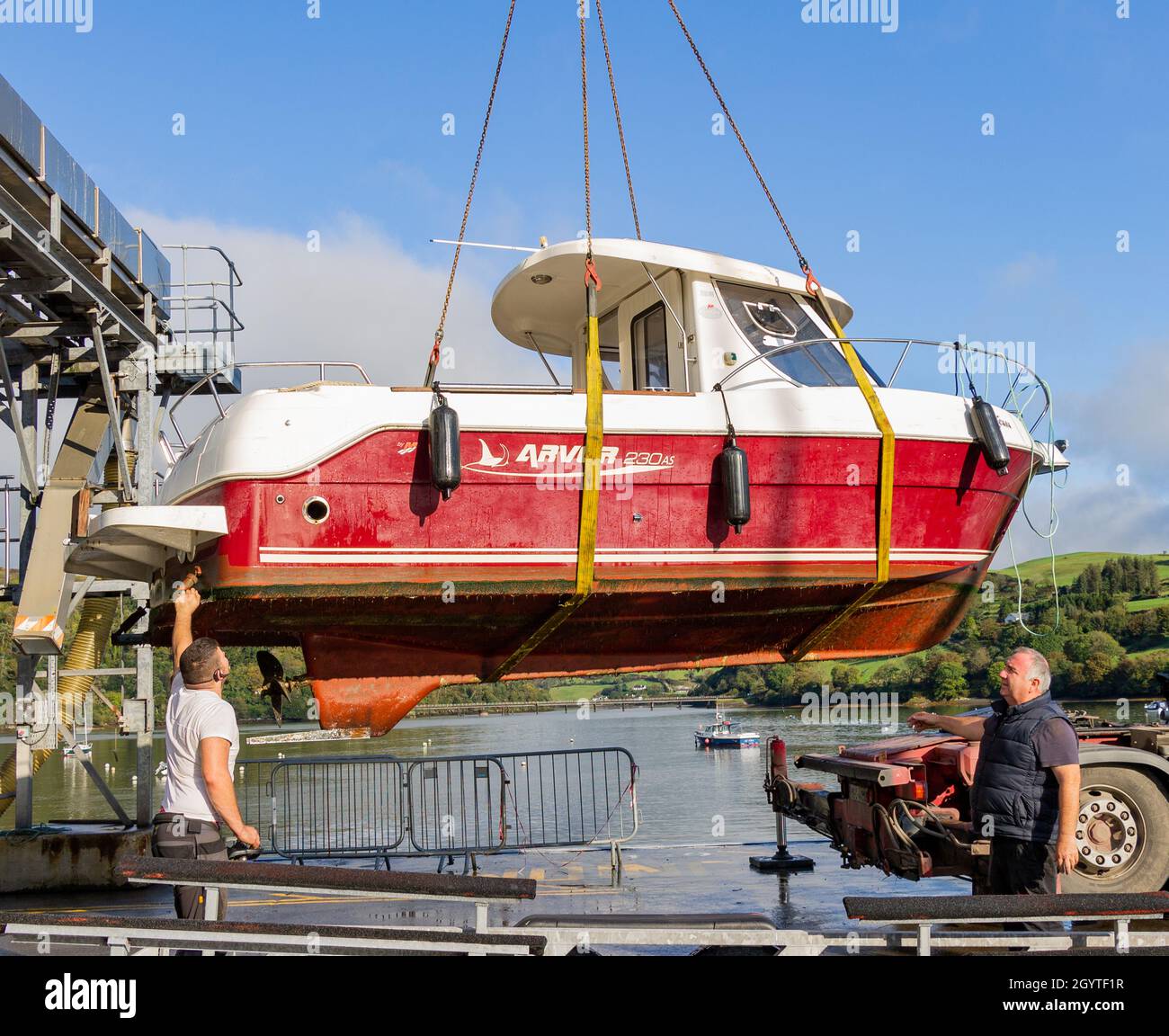 Two men guiding crane lifting boat hires stock photography and images