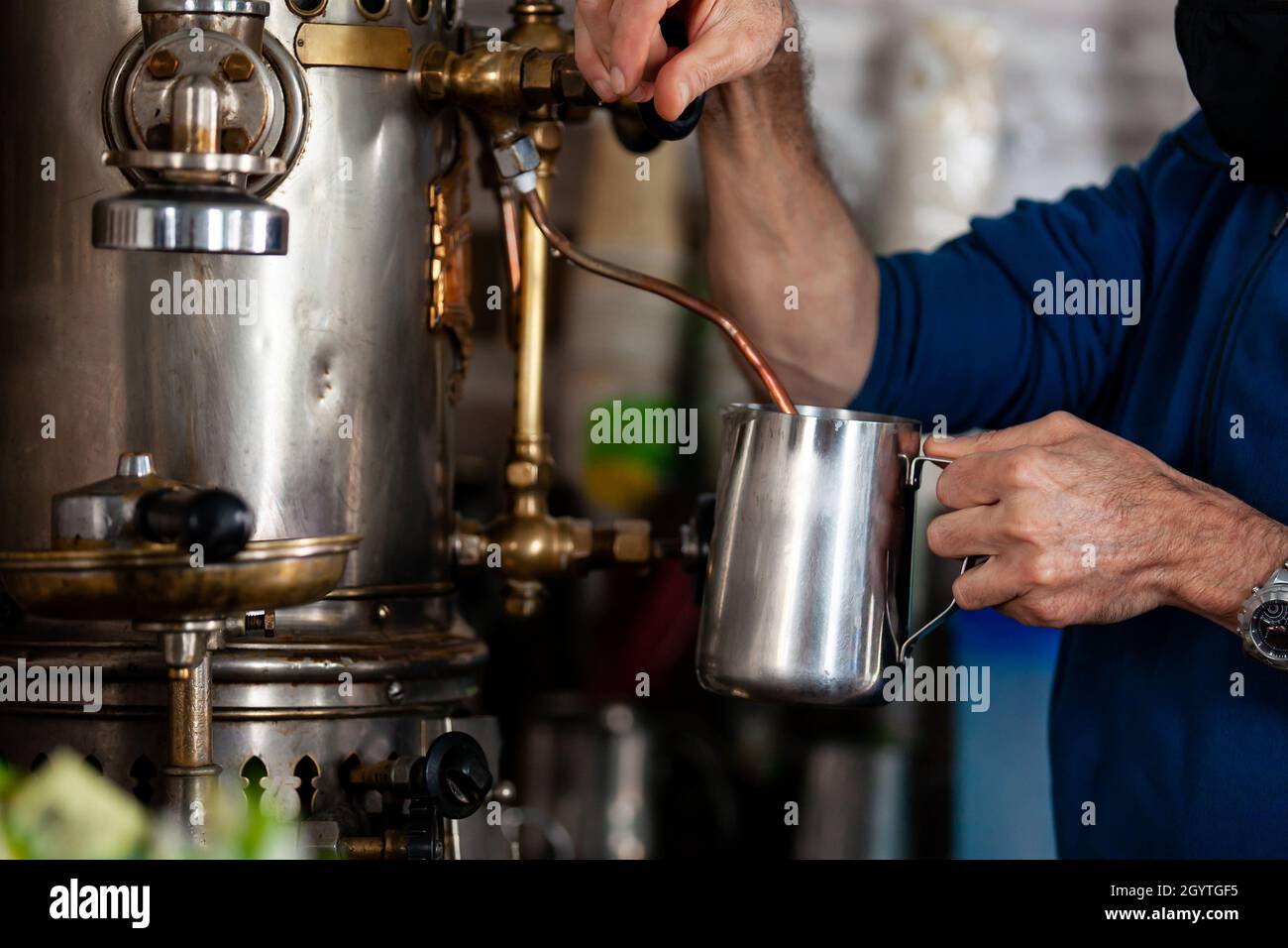 https://c8.alamy.com/comp/2GYTGF5/man-preparing-coffee-with-an-antique-coffee-maker-machine-2GYTGF5.jpg