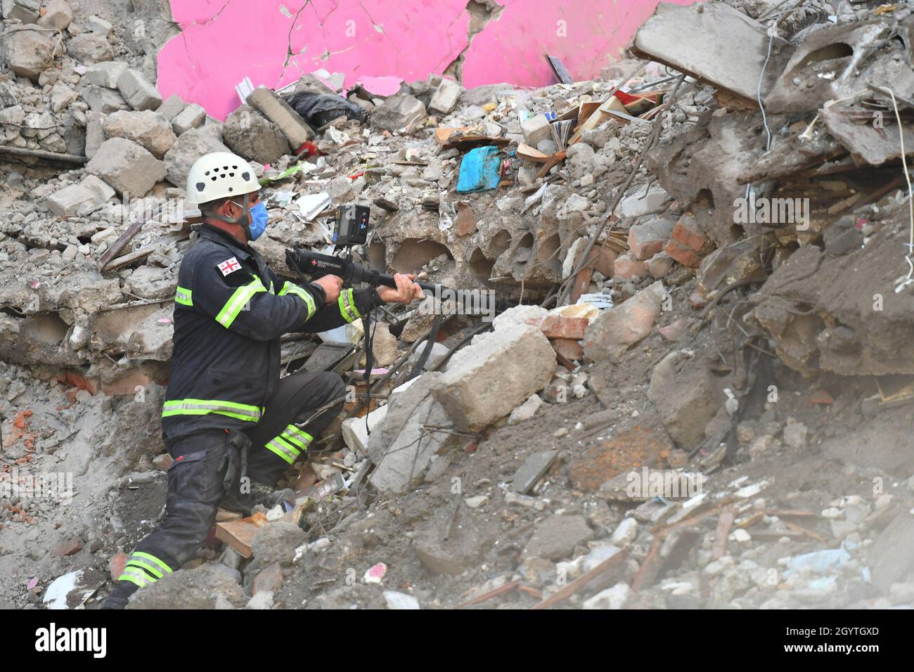 Tbilisi, Georgia. 9th Oct, 2021. A rescuer works on the ruins of a collapsed building in Batumi, Georgia, Oct. 9, 2021. Nine people were killed after a multi-block residential building collapsed in Georgia's Black Sea town of Batumi, the country's interior ministry said on Saturday. The collapse, which happened on Friday, was reportedly caused by violation of construction procedures that had damaged its retaining wall. Credit: Kulumbegashvili Tamuna/Xinhua/Alamy Live News Stock Photo