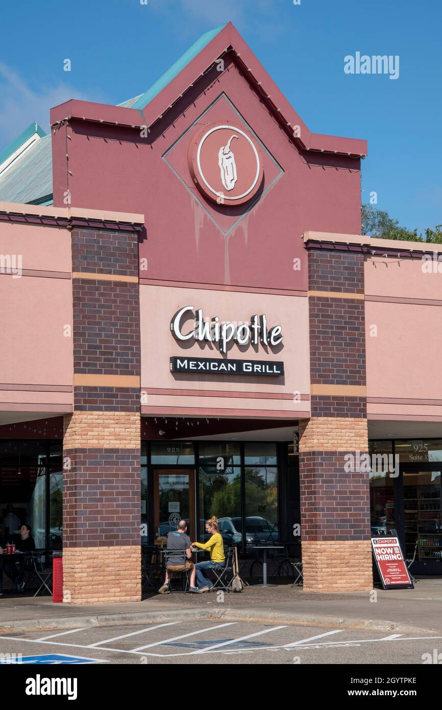 Vadnais Heights, Minnesota.  Couple eating outside on patio at Chipotle Mexican Grill with a now hiring sign. It is an American chain of fast casual r Stock Photo
