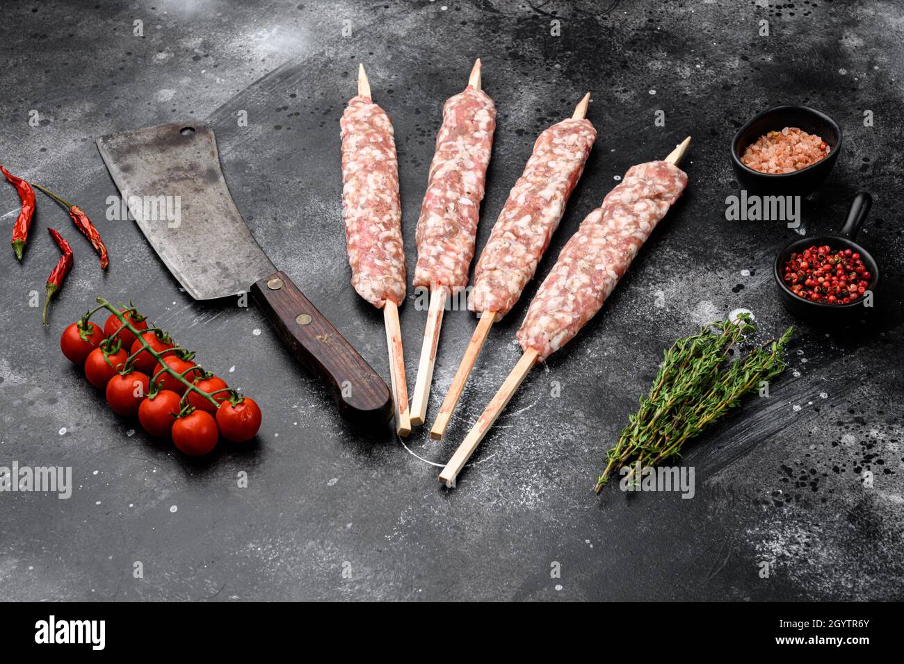 Raw Lula kebab on skewers set, with grill ingredients, on black dark stone  table background, with copy space for text Stock Photo - Alamy