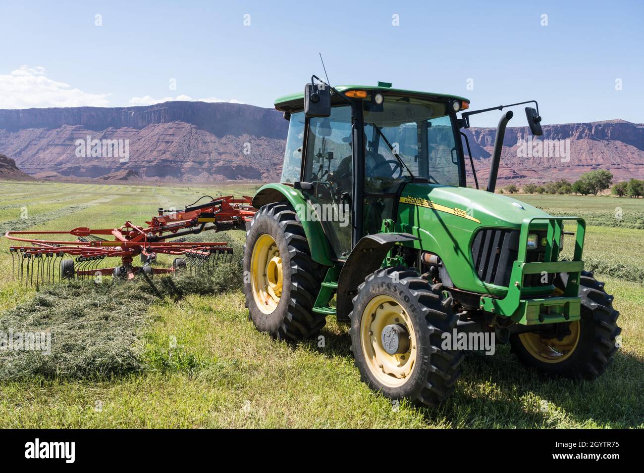 A rotary rake combines smaller rows of hay into one larger row to ...