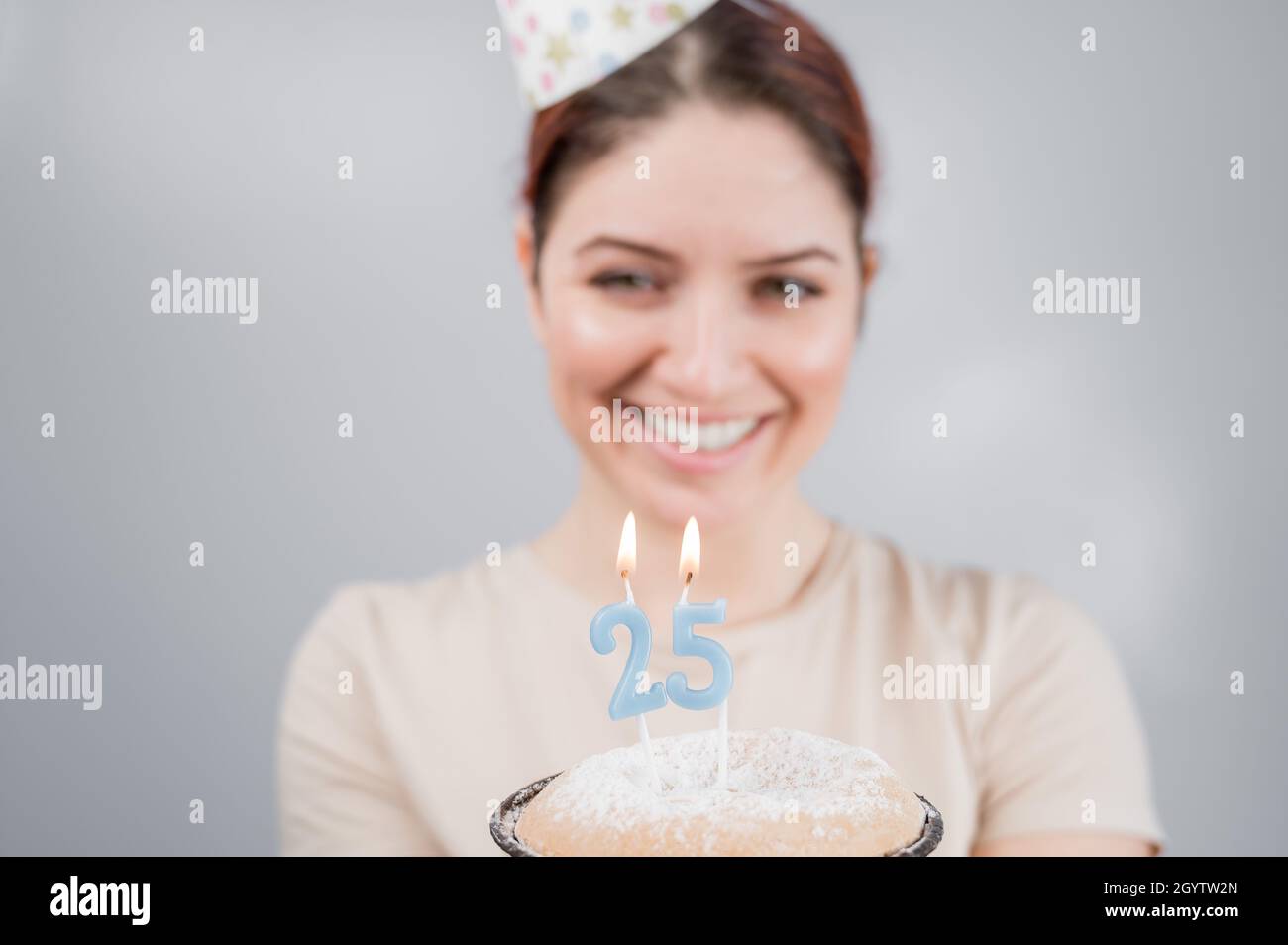 The happy woman makes a wish and blows out the candles on the 25th