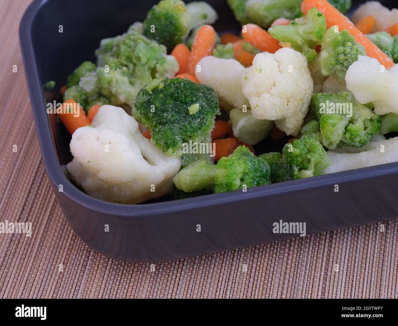 Frozen broccoli, cauliflower, and carrots in a tray. Close up Stock