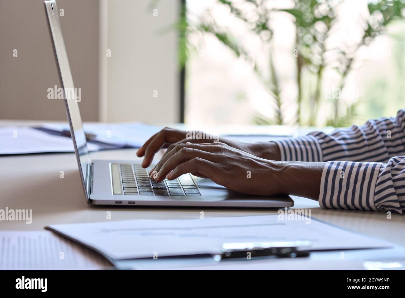 Young African black female hands typing on laptop computer keyboard. Stock Photo