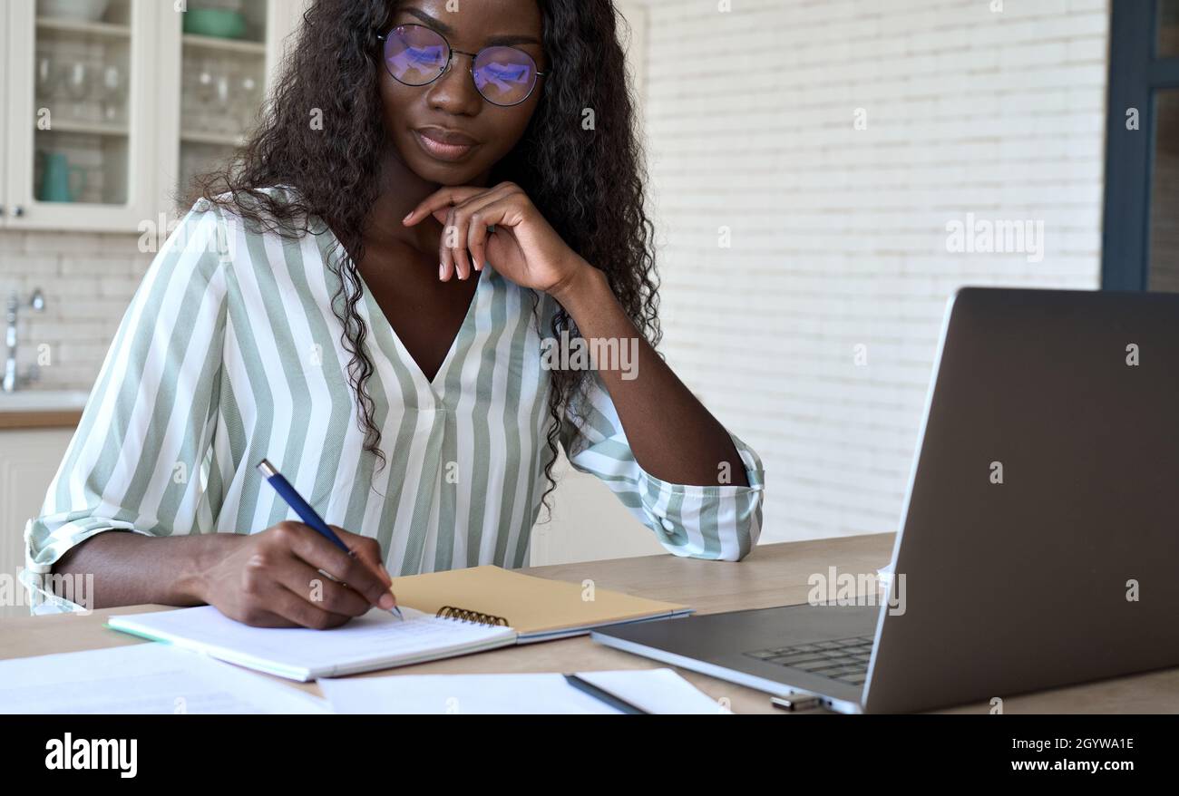 Young black African woman student learning online using laptop at home. Stock Photo
