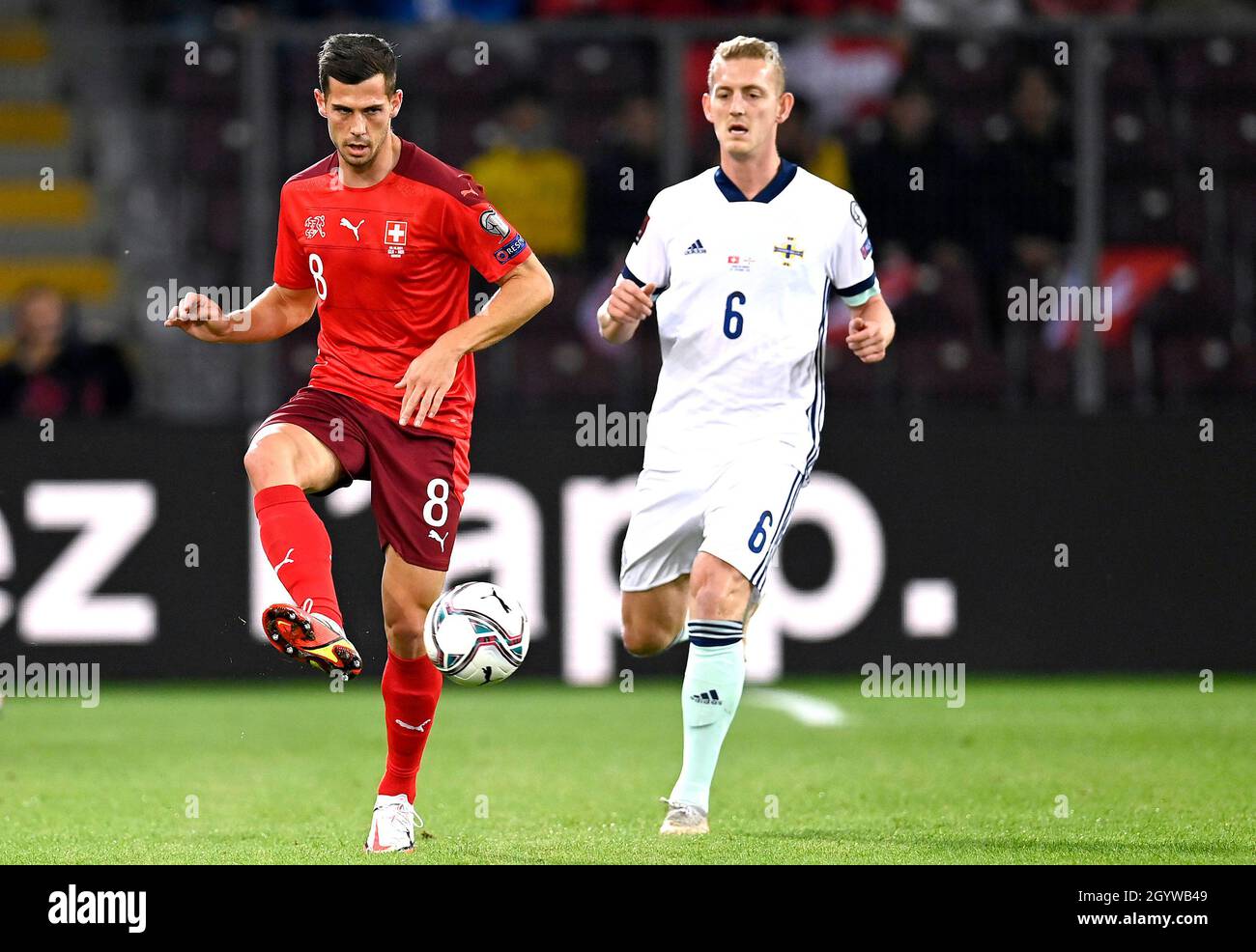 Switzerland's Remo Freuler (left) and Northern Ireland's George Saville battle for the ball during the FIFA World Cup Qualifying match at Stade de Geneve, Switzerland. Picture date: Saturday October 9, 2021. Stock Photo